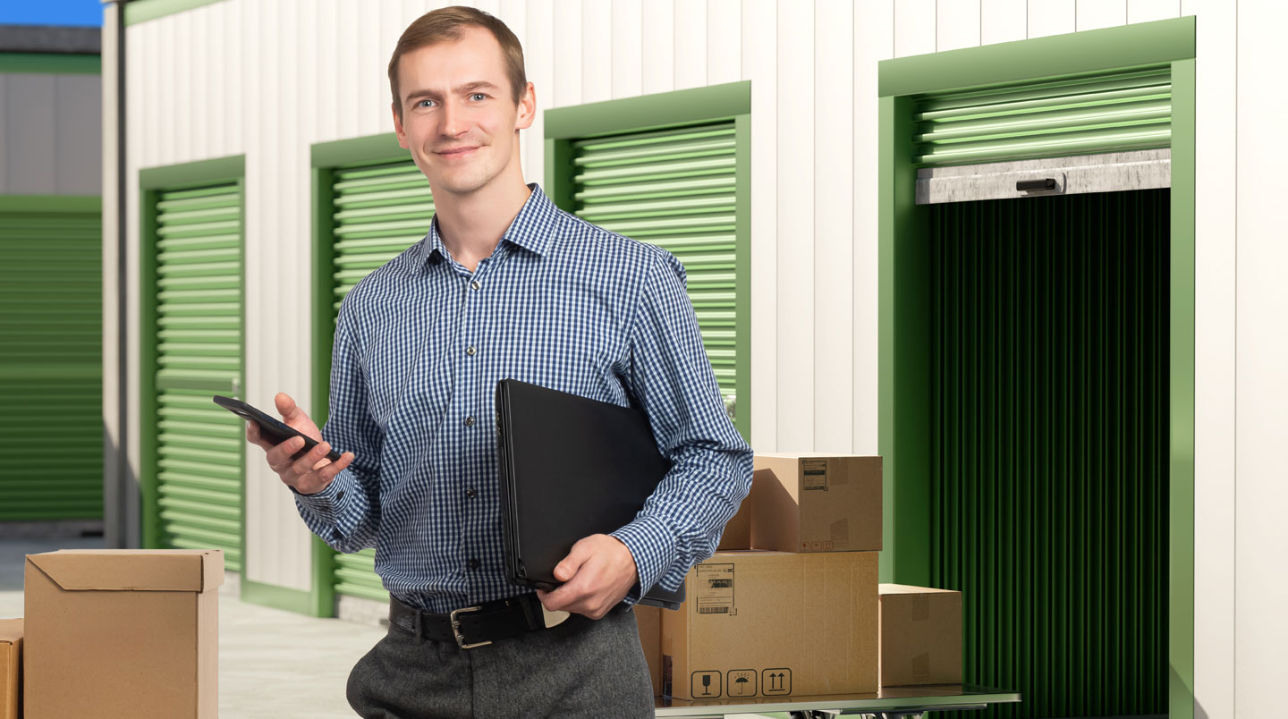 Client évaluant les dimensions d'un box de stockage ouvert dans une installation moderne et sécurisée